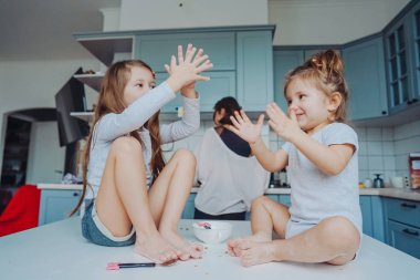 Mutfakta masada oturan iki küçük kız..