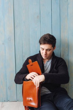 Deri çantalı yakışıklı adam.