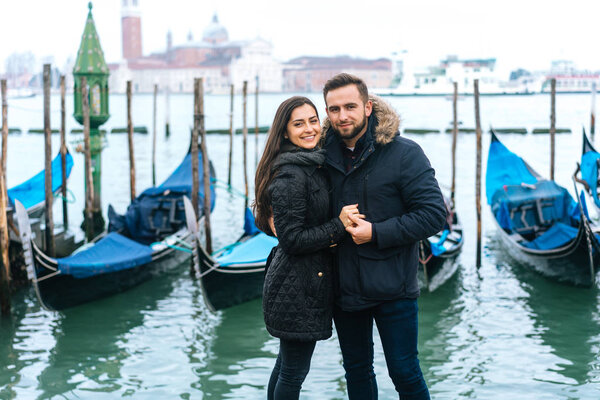 guy and girl posing in the background gondolas