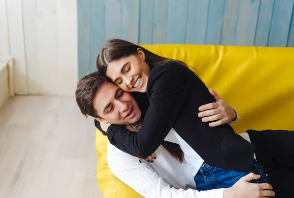 Cara e menina em um sofá amarelo — Fotografia de Stock