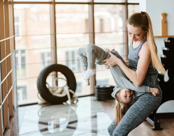 Anne ve kızı birlikte farklı egzersizler yapıyorlar. — Stok fotoğraf