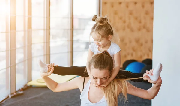 A small daughter sits at her mothers back — Stock Photo, Image