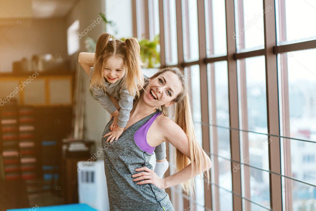 Mom and daughter together perform different exercises