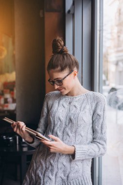 Asyalı kadın yakınındaki Cafe Restoran pencerede tablet bilgisayarda kullanma,