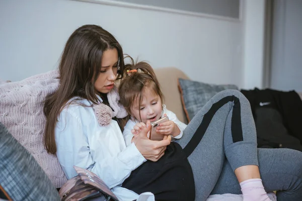 Máma a dcera se díváte na smartphone — Stock fotografie