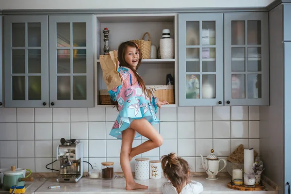 Twee kleine meisjes zijn op zoek naar cookies — Stockfoto