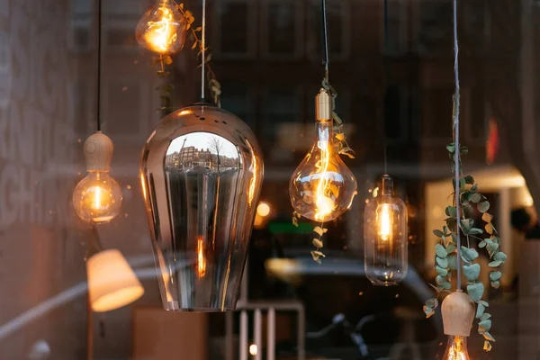 Incandescent lamps in room behind the glass — Stock Photo, Image