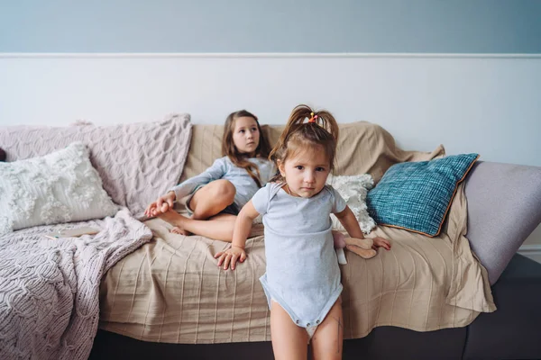 Two little girls in a room on the couch — Stock Photo, Image