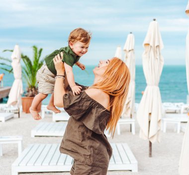 Anne ve küçük oğlu sahilde, tatildeler.