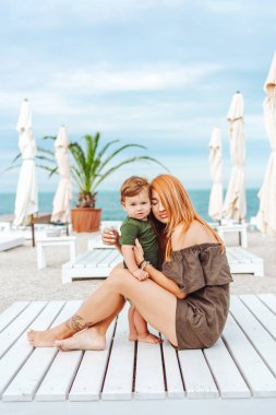 Anne ve küçük oğlu sahilde, tatildeler.