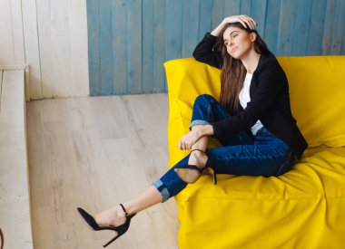 Sarı koltukta oturan genç kadın.