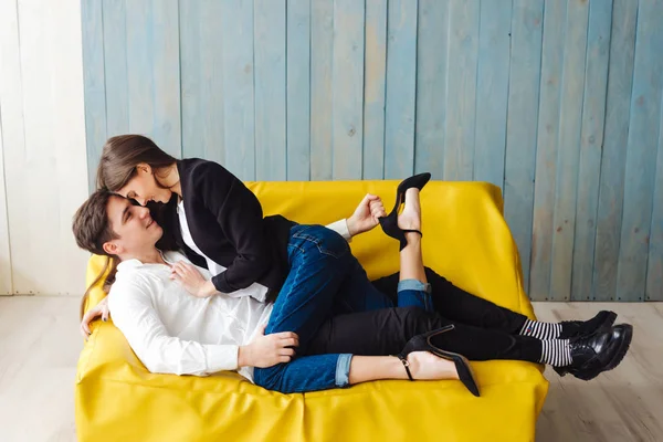 Парень и девушка на жёлтом диване — стоковое фото