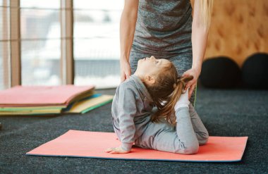 Küçük bir kız annesi için egzersizleri tekrarlıyor.