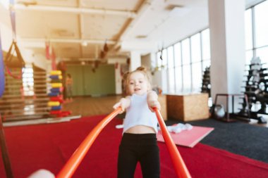 Küçük kız ve anne sopayla egzersiz yapıyor.