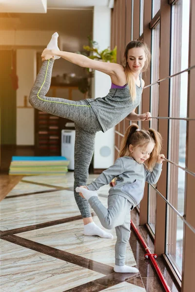 Mom and daughter together perform different exercises — Stock Photo, Image