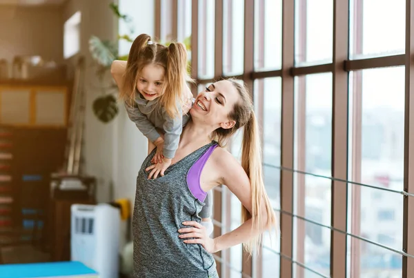 Anne ve kızı birlikte farklı egzersizler yapıyorlar. — Stok fotoğraf