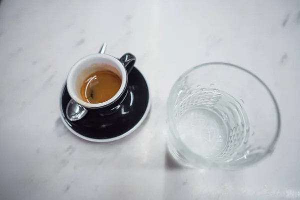 Coffee mug and a glass of water on a table — Stock Photo, Image