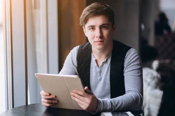 Молодой человек с планшетным компьютером в кафе — стоковое фото