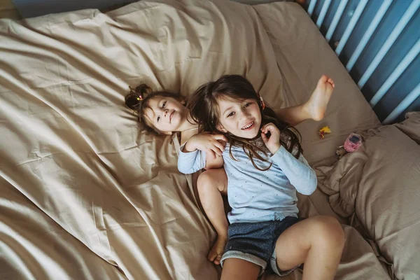 Happy little girls lying on back top view sisters — Stock Photo, Image