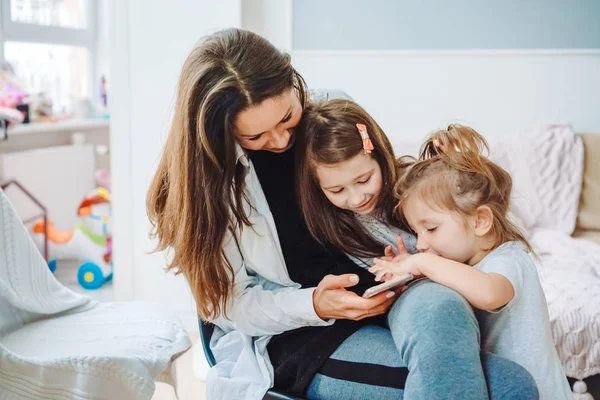 Anne ve iki kızı smartphone vasıl arıyoruz — Stok fotoğraf