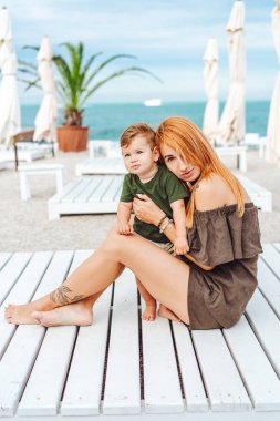 Anne ve küçük oğlu sahilde, tatildeler.