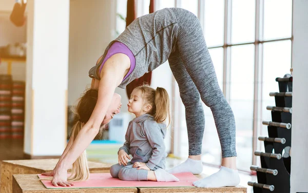 Mamá e hija juntas realizan diferentes ejercicios — Foto de Stock