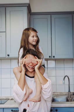 Güzel küçük kızım mutlu annesini sırtında taşıyor.