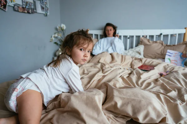 Moeder met haar dochter liggend op bed — Stockfoto