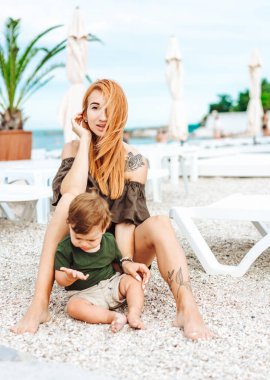 Anne ve küçük oğlu sahilde, tatildeler.