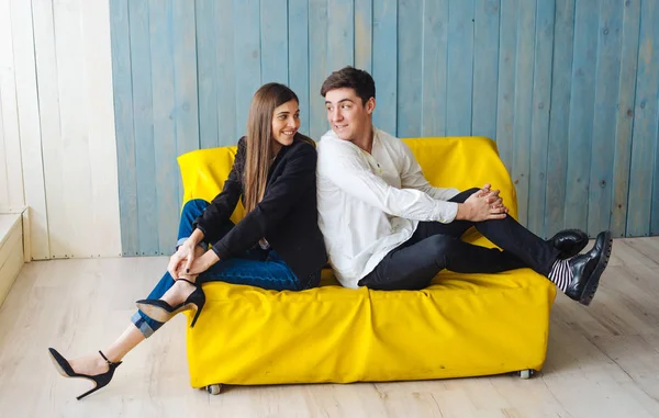 Ragazzo ragazza su il giallo divano — Foto Stock