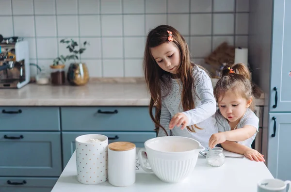 Two little girls cook in the kitchen — Stock Photo, Image