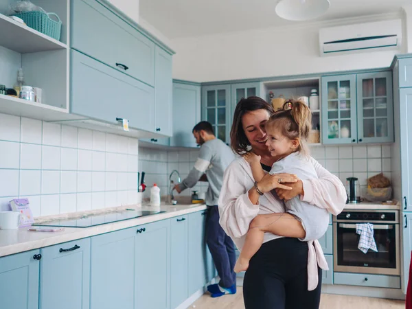 Papá, mamá, hija pequeña en la cocina — Foto de Stock