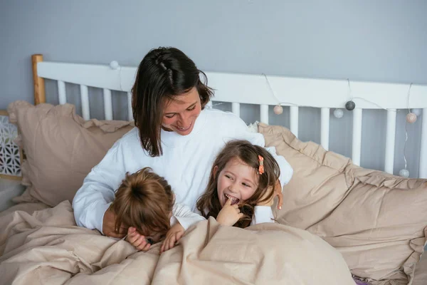 Mom and her two little cute daughters are having fun — Stock Photo, Image