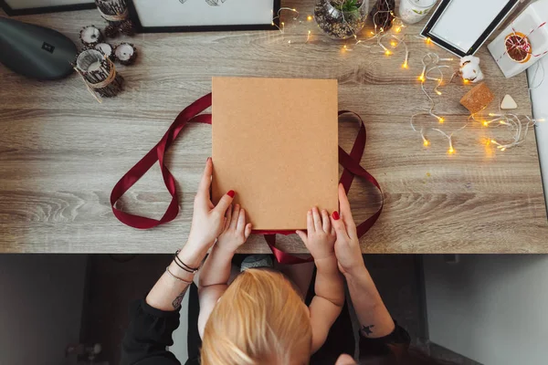 ผู้หญิงห่อของขวัญในกระดาษด้วยริบบิ้นสีแดง . — ภาพถ่ายสต็อก