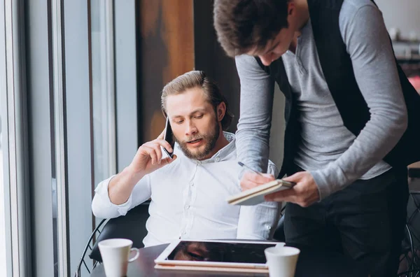 Due uomini d'affari discutono di lavoro e utilizzano tablet — Foto Stock