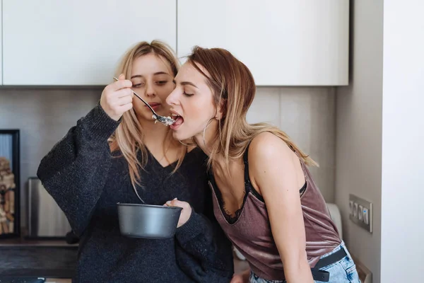 Duas meninas comem mingau em casa — Fotografia de Stock