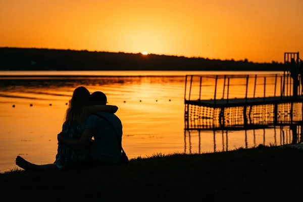 Young couple resting on the river bank — Stock Photo, Image