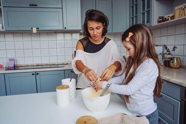 mom teaches her little daughter to cook food