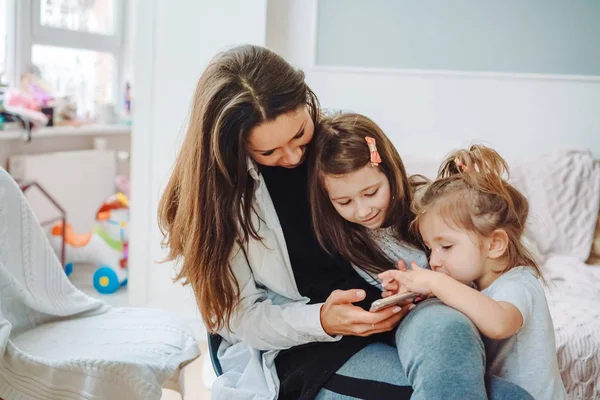 Anne ve iki kızı smartphone vasıl arıyoruz — Stok fotoğraf