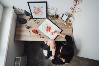 Young woman painting with watercolor paints clipart