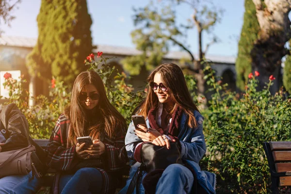 Duas meninas estão descansando no banco — Fotografia de Stock