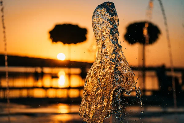 Fluxo Uma Fonte Espirra Água Contra Fundo Pôr Sol — Fotografia de Stock