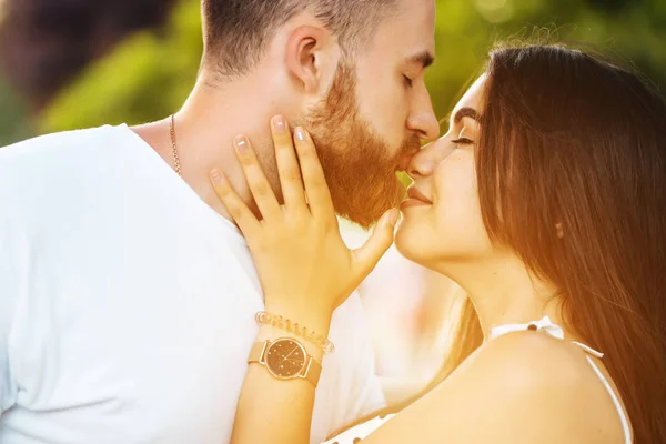 Handsome guy and beautiful girls kissing in the park — Stock Photo, Image