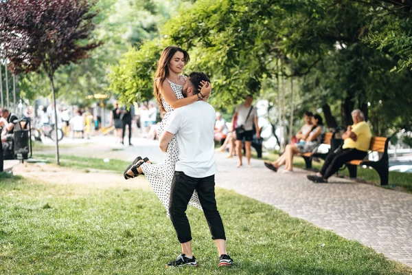 Handsome guy in his arms holding a beautiful girl — Stock Photo, Image