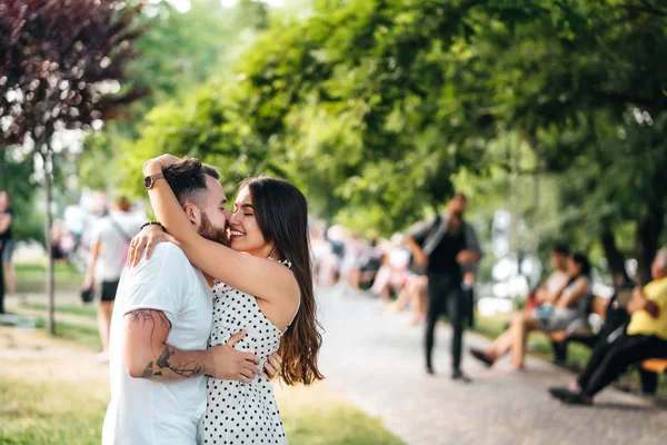 Красивый парень и молодая девушка обнимаются в парке . — стоковое фото