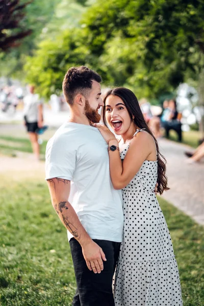 Bonito cara abraçando sua namorada no parque . — Fotografia de Stock
