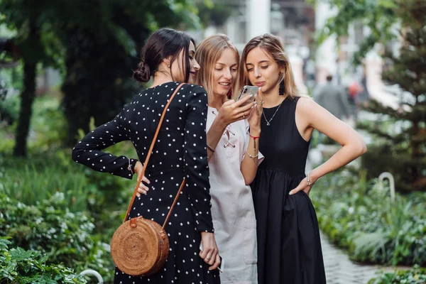 Três meninas olham para a foto — Fotografia de Stock