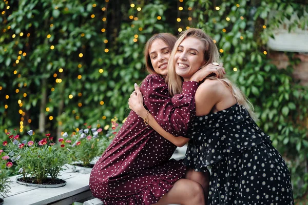 Duas meninas no parque abraçando no banco — Fotografia de Stock