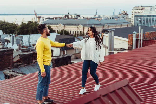Любляча молода пара стоїть на даху будинку . — стокове фото
