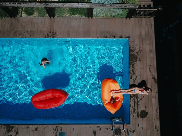 Mamá e hijas descansan en la piscina . — Foto de Stock